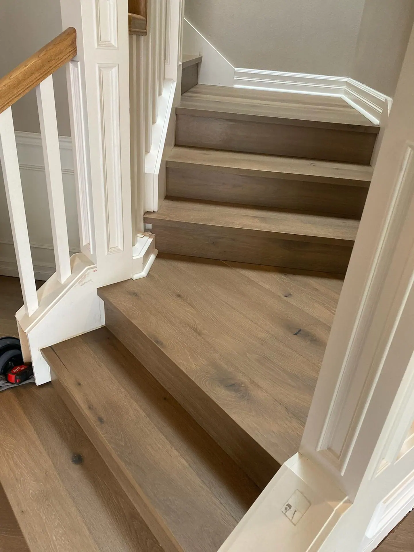 Custom wood handrail and newel post on a finished staircase in Seattle, Washington.