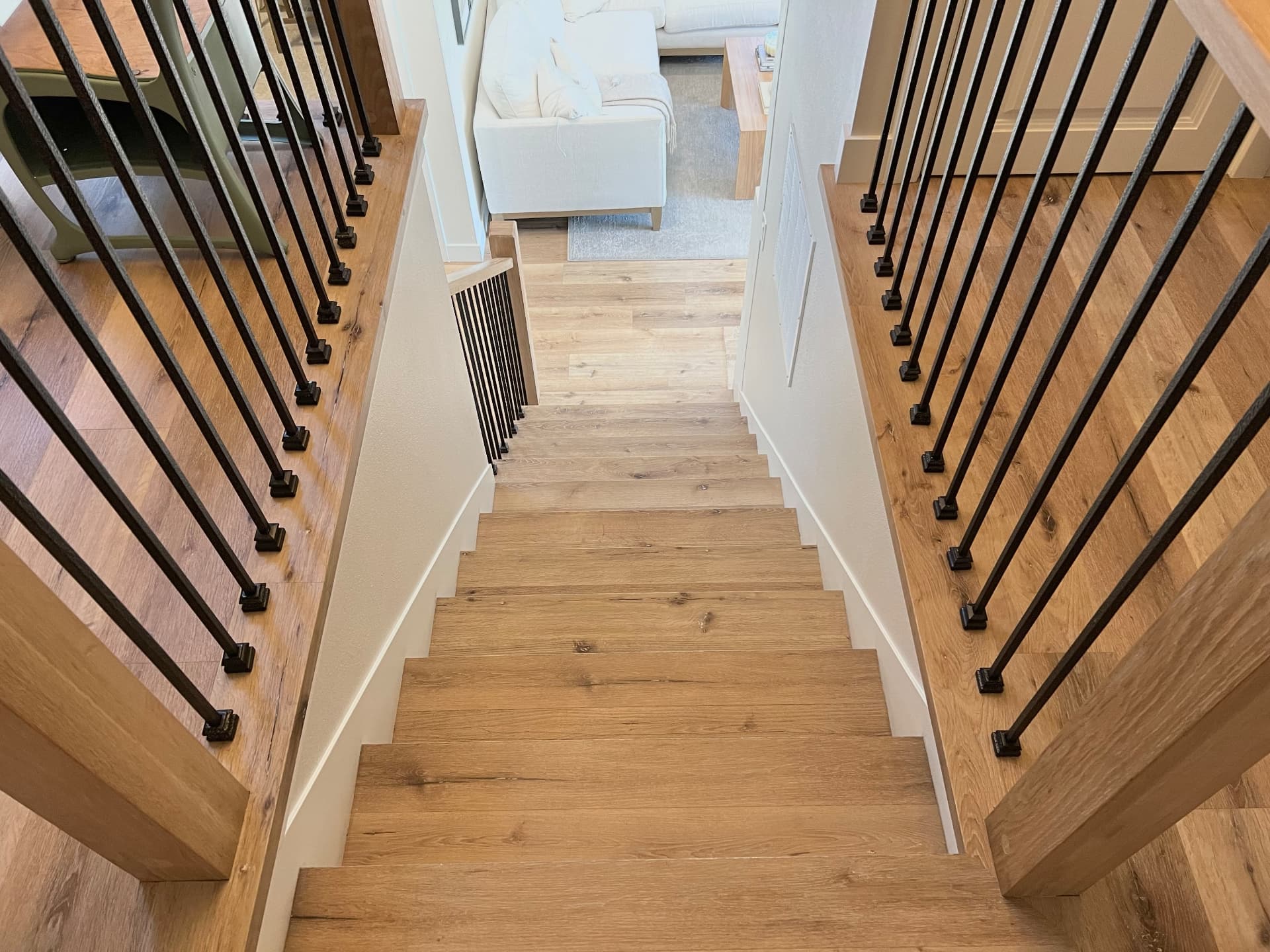 Luxury vinyl plank stair nosings and risers on a double-railing stairwell viewed from the top in Tacoma, Washington.